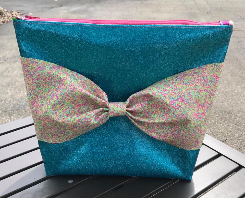 Trish's glittery teal bag with bow detail