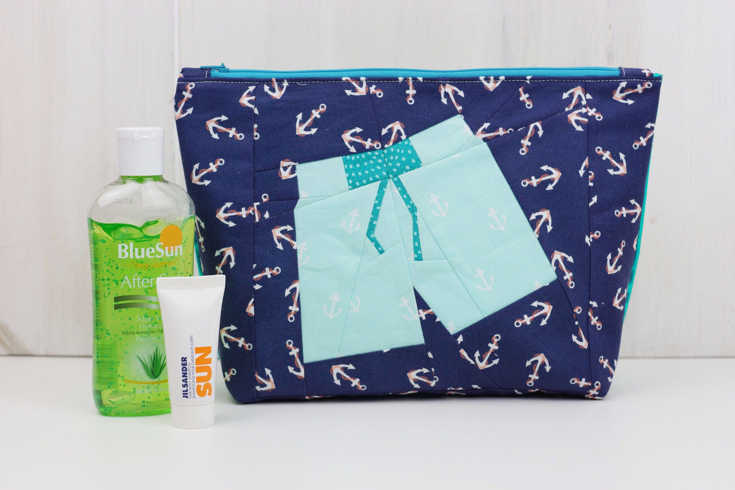 Navy anchor pouch with two-piece shorts design, aloe vera, and sunscreen.