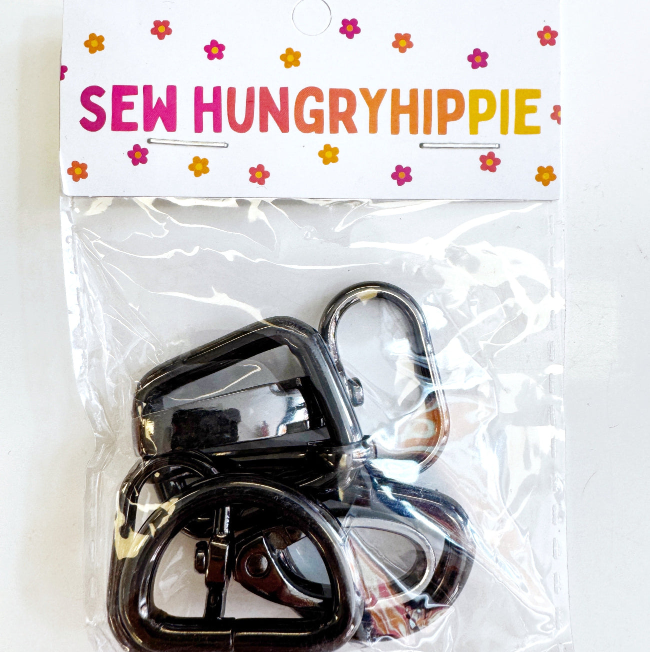 A package of 1-inch gunmetal finish swivel hooks for bag making, branded with a Sew Hungry Hippie header card.