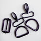 Five dark metallic carabiner clips and loops in a glossy black finish, arranged on a plain light background.