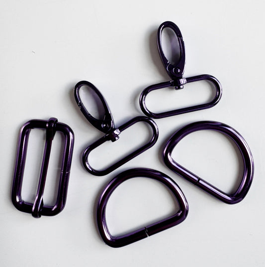Five dark metallic carabiner clips and loops in a glossy black finish, arranged on a plain light background.