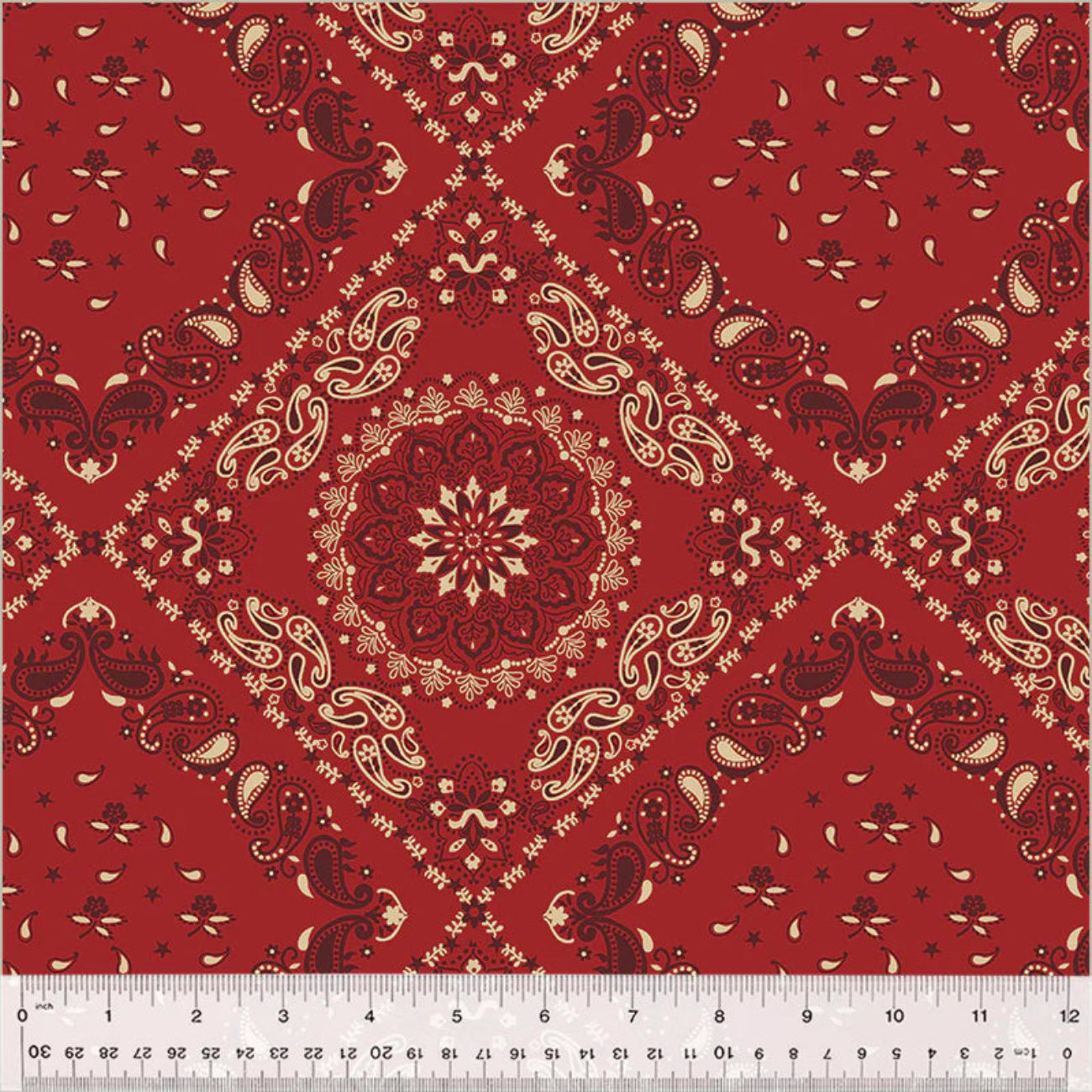 Traditional bandana-style quilt backing fabric featuring a large, intricate central mandala emblem enclosed in a diamond trellis pattern. The design includes classic paisley motifs, small stars, and floral elements in cream and dark burgundy-red over a rich crimson red background.