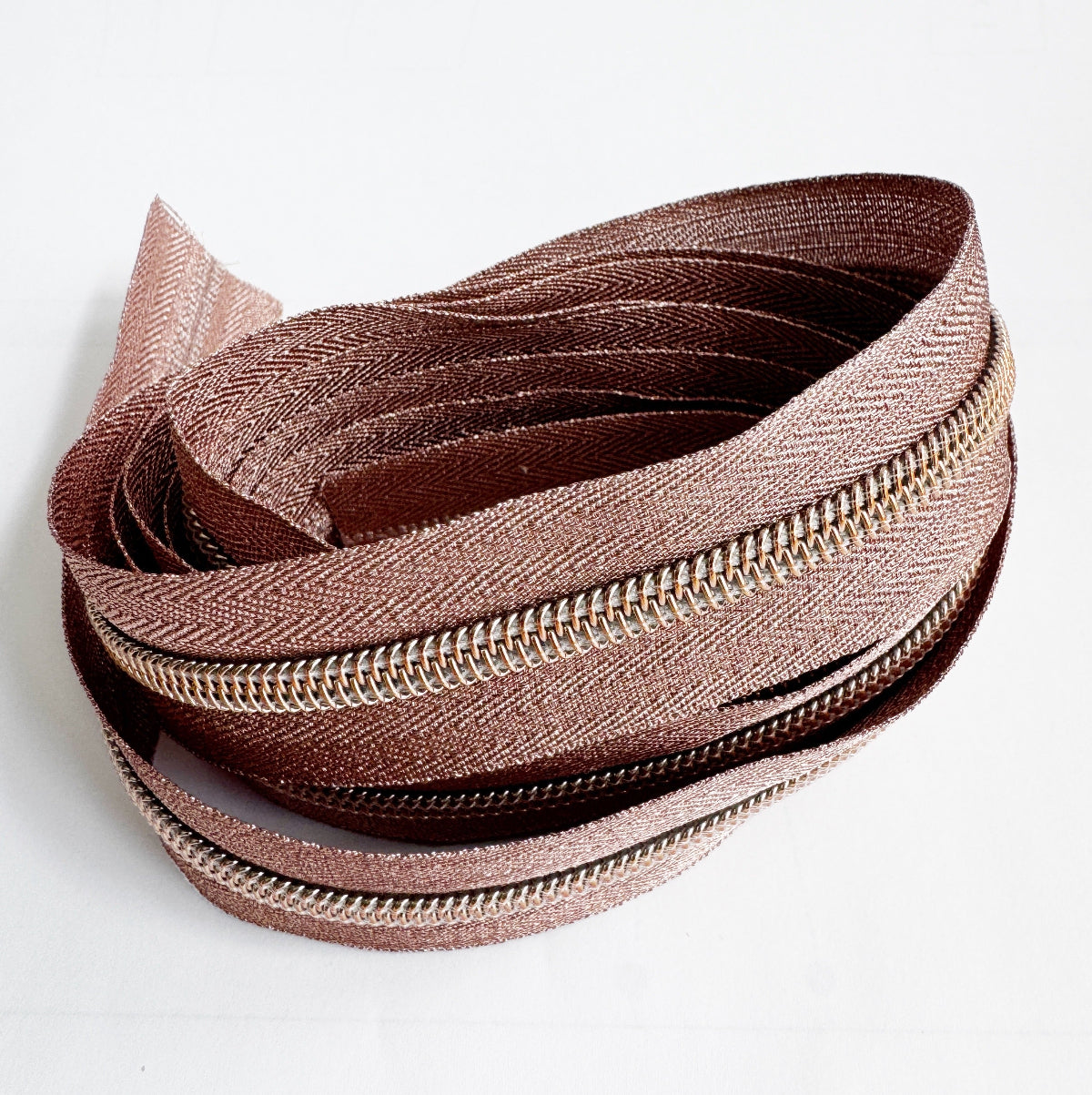 Close-up of a brown zipper on a white background