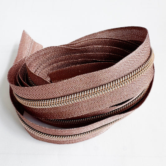 Close-up of a brown zipper on a white background