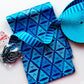 A folded piece of cotton fabric, roughly 1 yard, featuring a complex, dark blue geometric and leaf-like triangle pattern on a lighter blue background.