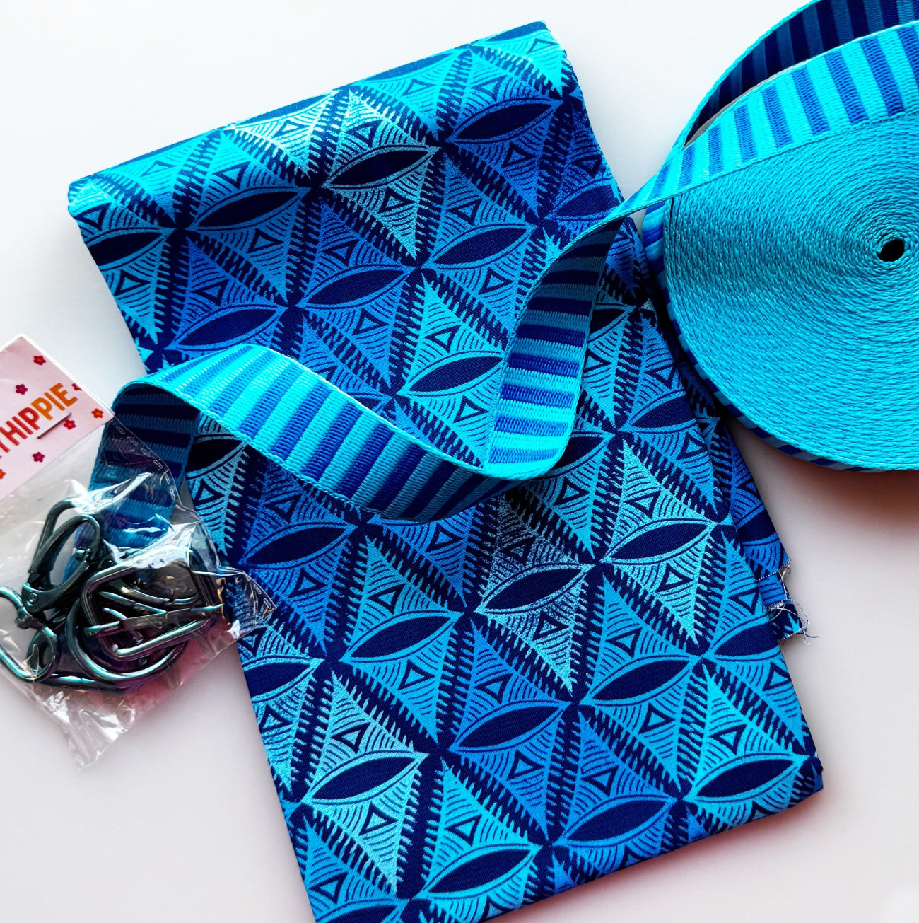 A folded piece of cotton fabric, roughly 1 yard, featuring a complex, dark blue geometric and leaf-like triangle pattern on a lighter blue background.