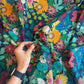 Colorful floral fabric with a hand holding it
