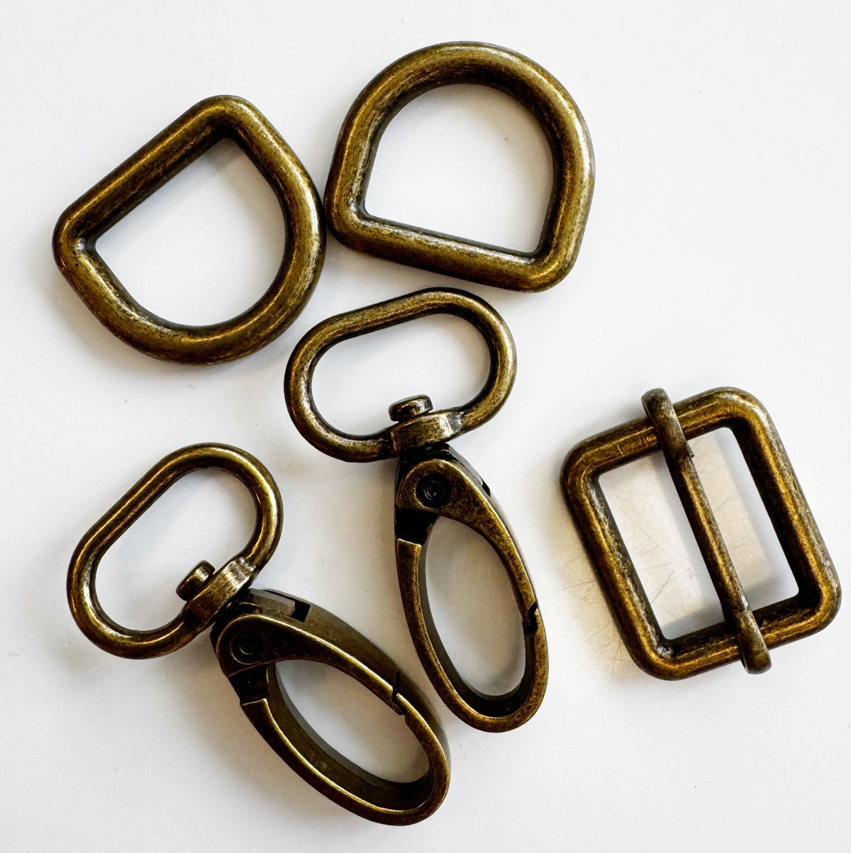 Set of five brass buckles on a white background