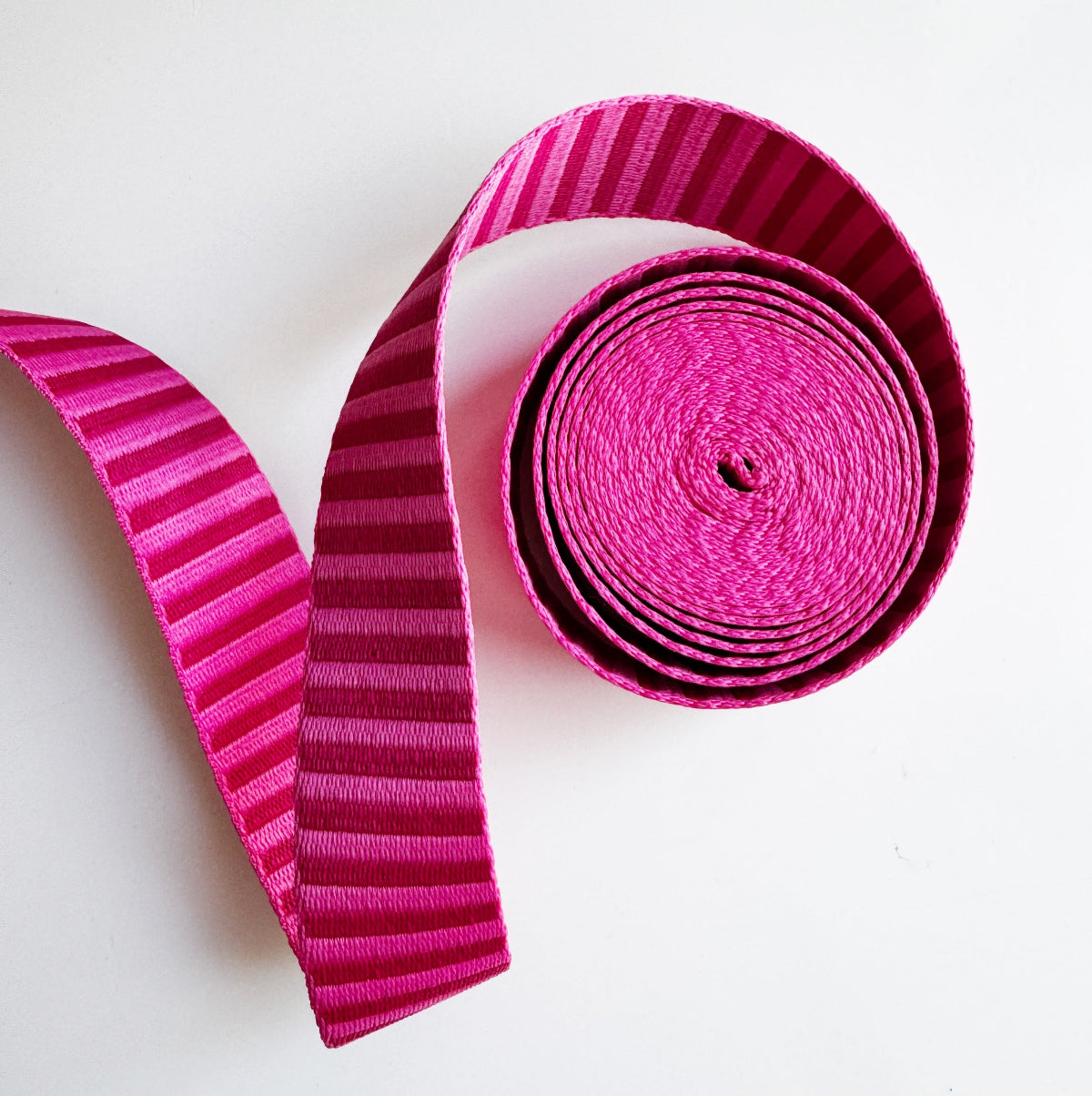 Pink striped webbing or straps on a white background