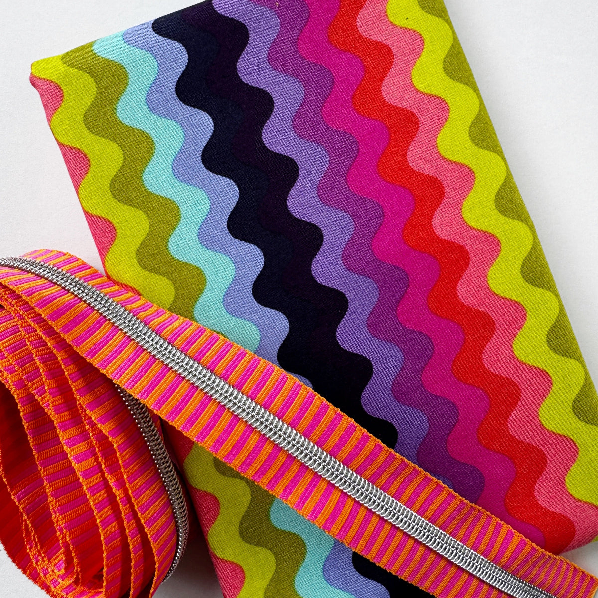 Colorful fabric with wavy pattern and zipper on a white background
