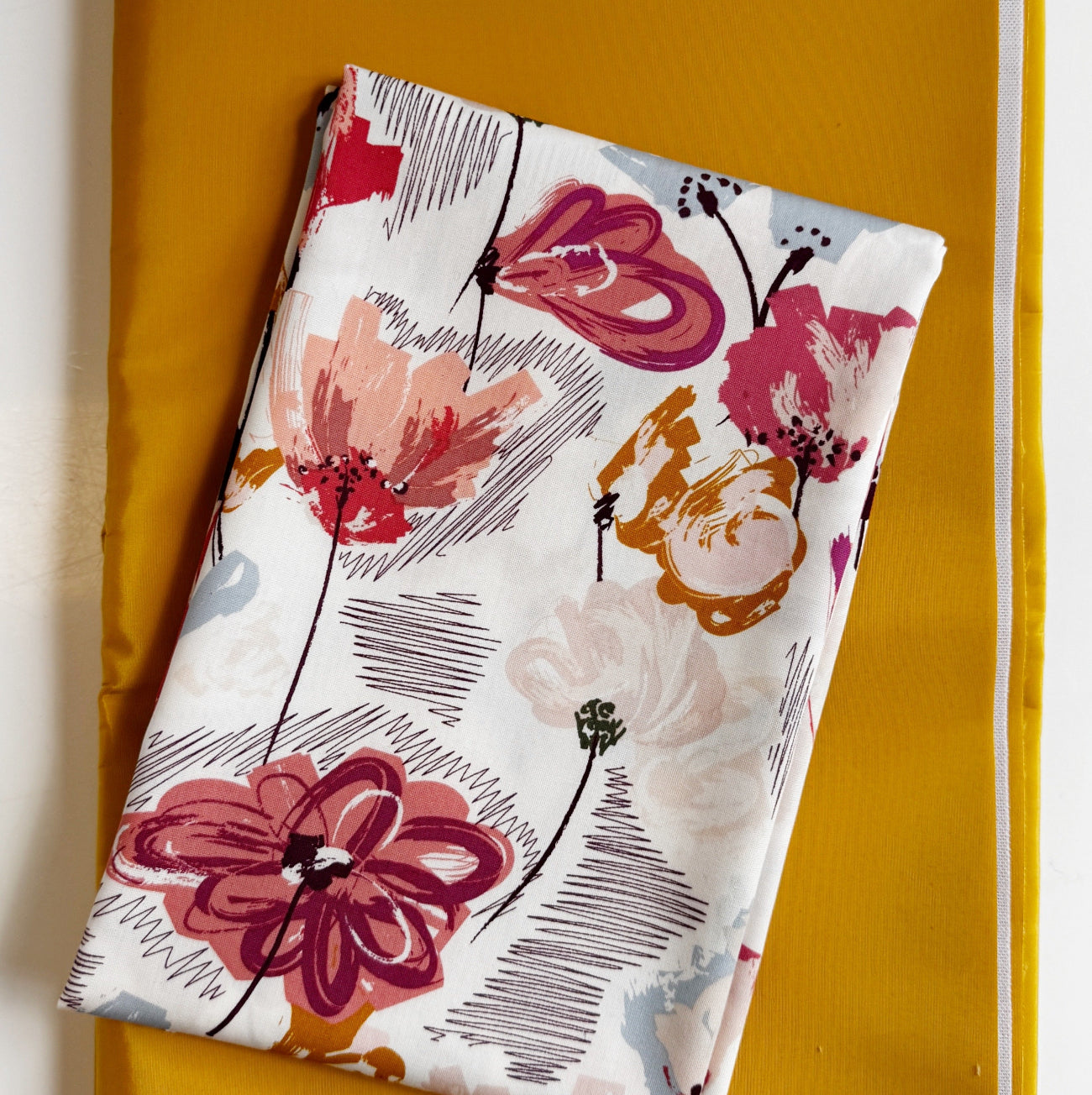 Retro mid-century modern abstract floral cotton fabric with mauve pink and mustard yellow flowers, paired with a solid mustard yellow canvas base fabric for quilting and bag making.