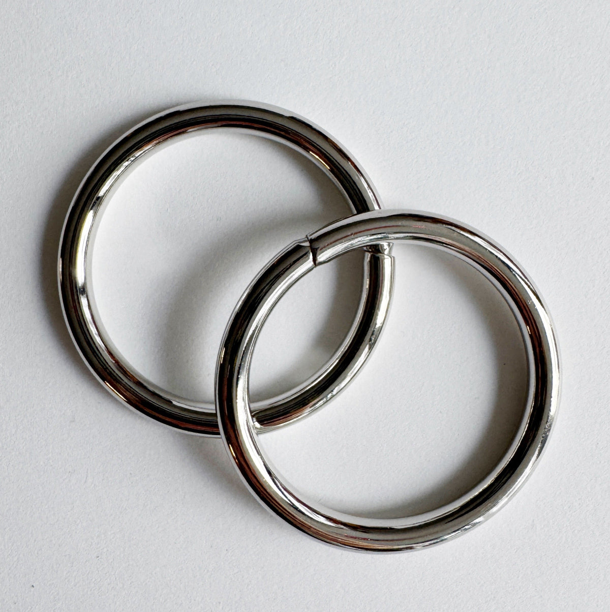 Two metallic rings on a light gray background