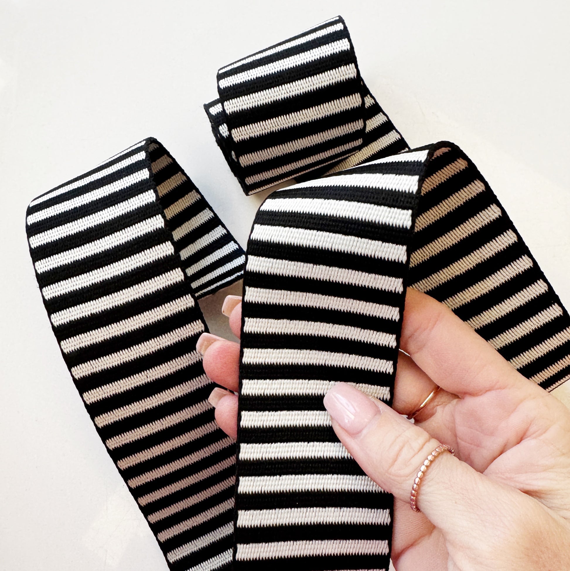 Black and white jacquard woven stripe webbing, 2-inch width, sold per yard. Strong decorative strap material for bag straps, purse handles, belts, and sewing projects.