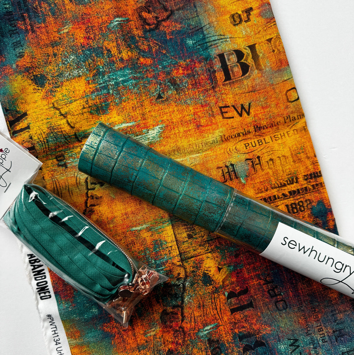 Green fabric roll and packaging on a textured surface with visible branding.
