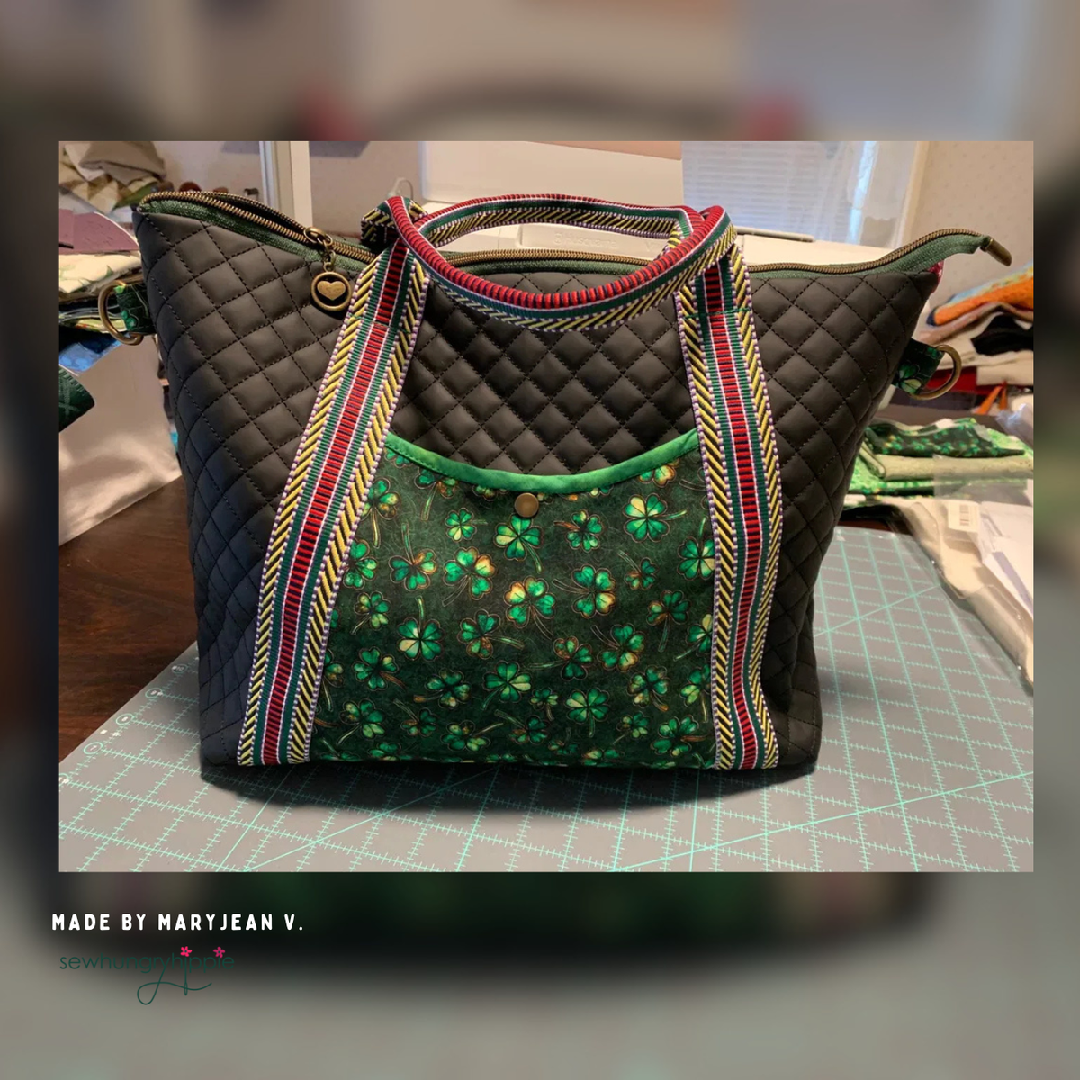 Black quilted vinyl tote with a green sequin pocket and striped handles