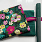 Green cork roll with pink floral cotton fabric, Windham Radiance Fabric Hunter color, and bright pink zipper tape arranged as a coordinated bag making bundle.
