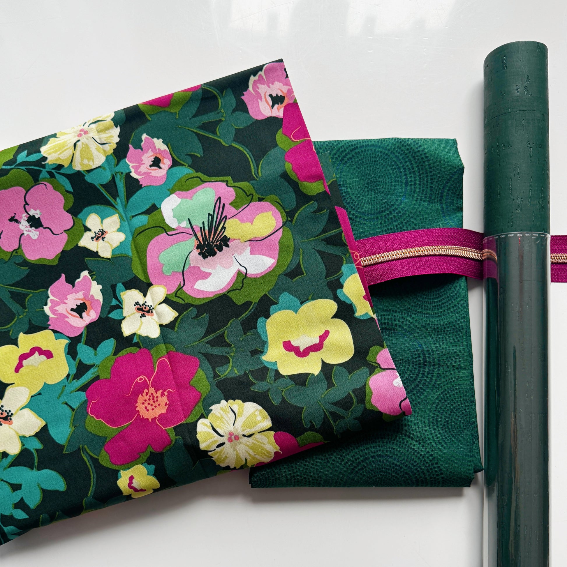 Green cork roll with pink floral cotton fabric, Windham Radiance Fabric Hunter color, and bright pink zipper tape arranged as a coordinated bag making bundle.