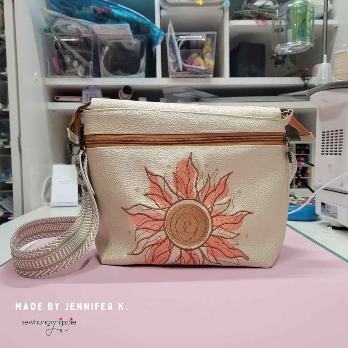Champagne Moonglow vinyl crossbody bag with embroidered pink sun and striped strap, made by Jennifer K.