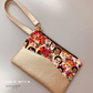 Champagne Moonglow vinyl wristlet with floral portrait print panel, made by Betty M.