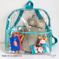 Clear vinyl backpack with teal binding and mesh side pockets holding a plush toy and snacks, made by Elizabeth B.