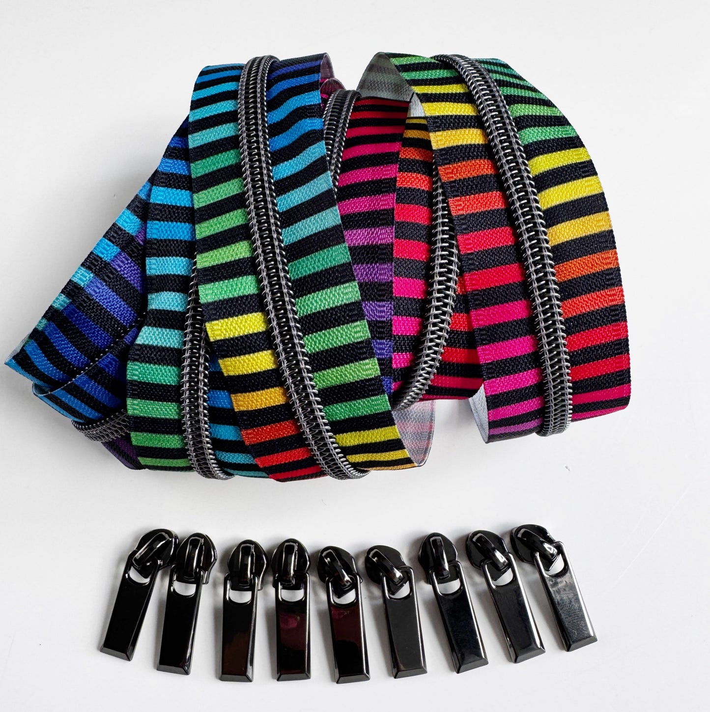 Colorful striped zippers and black zipper pulls on a white background