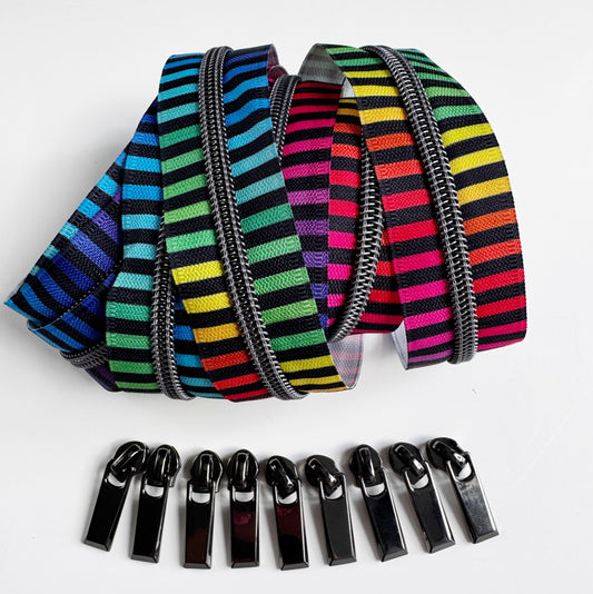 Colorful striped zippers and black zipper pulls on a white background
