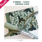 image showcases coordinating materials including a teal and gold dragon motif cotton fabric, a roll of textured sage green vinyl, and matching sage zipper tape on a clean white background.