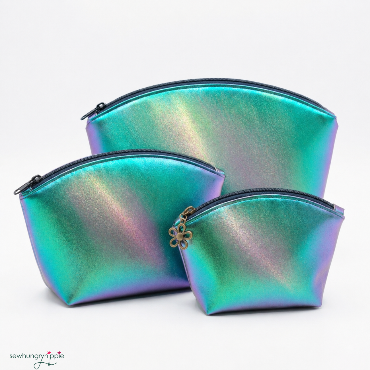 Three graduated sizes of handmade zipper pouches made from iridescent green and purple color-shifting vinyl.