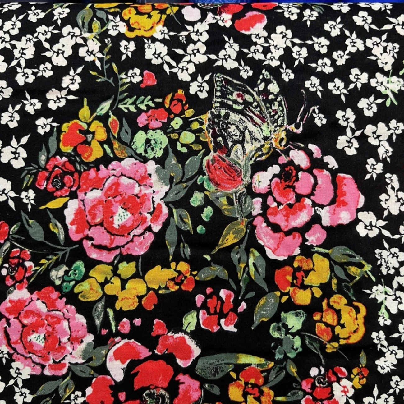 High-quality rayon challis fabric featuring pink, orange, and white floral motifs with butterflies on dark navy black base.