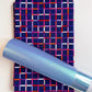 Dark navy blue cotton fabric with a colorful geometric grid plaid pattern paired with a coordinating iridescent light blue faux leather vinyl roll for handmade bag making and sewing.