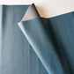 Blue faux-leather fabric with a textured surface on a white background