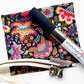 Sewing kit or bag-making supply bundle from Sew Hungryhippie, featuring a dark floral print fabric, a roll of navy blue cork  a white zipper tape in bronze teeth, and  bronze hardware d-rings and shivels.