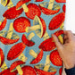 Hand holding fabric mushroom print in blue background by FreeSpirit Forage Toadstool Fabric