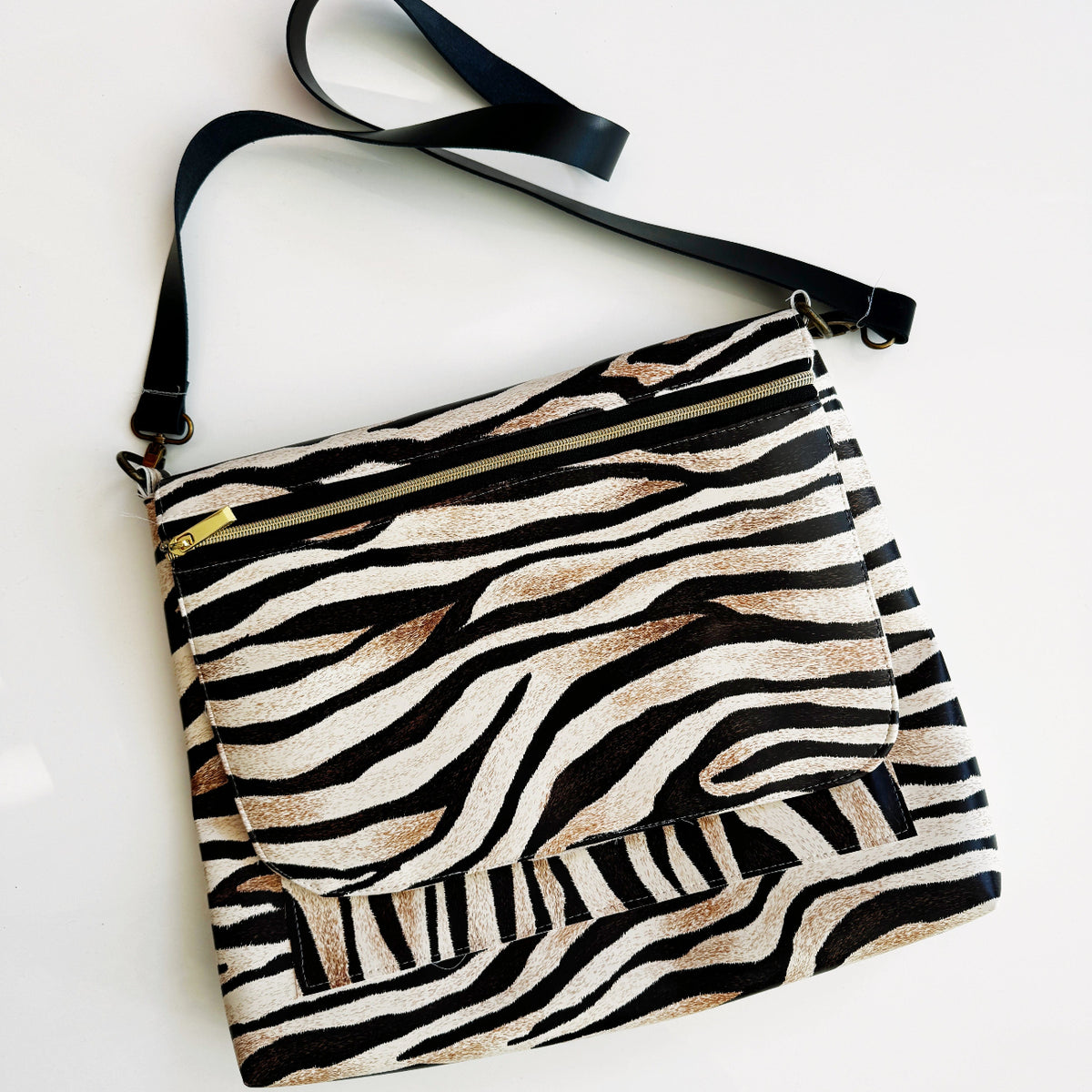 Zebra print crossbody bag with black strap.