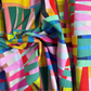 Colorful fabric with geometric patterns in various bright colors.