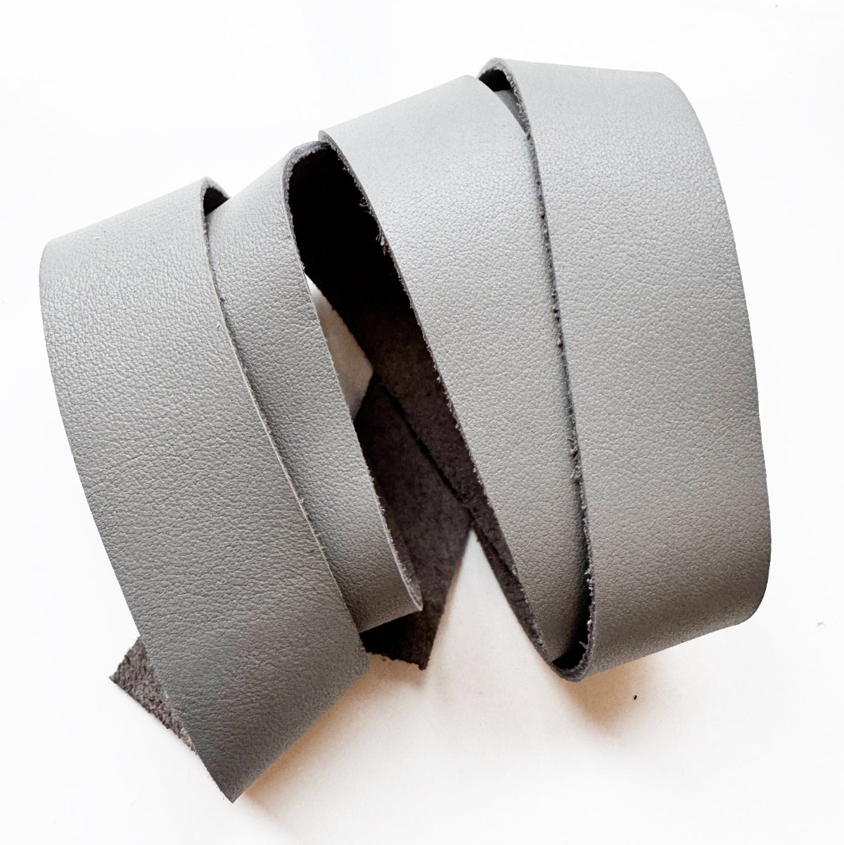 Grey leather strap, a flat leather strip or belt blank used for bag crafting.