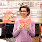 Natalie holding a heart-shaped pink pot holder in the Sew Hungry Hippie sewing studio