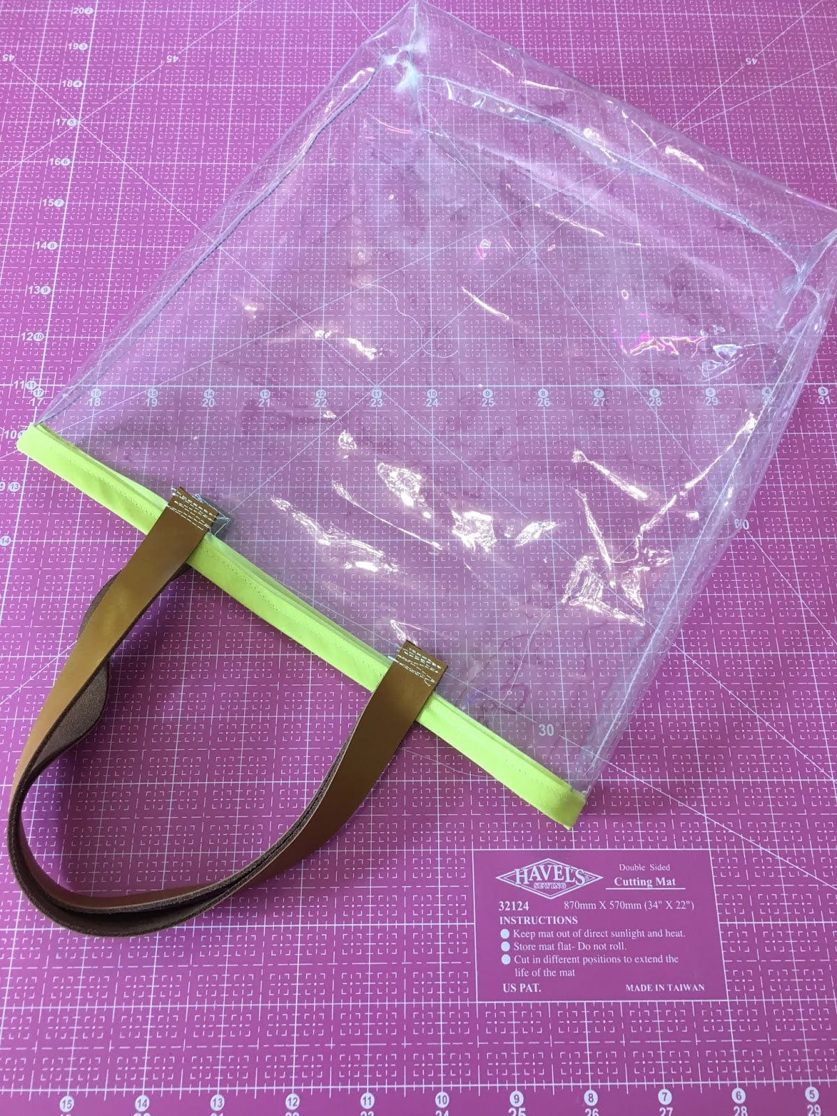 Clear tote bag with brown handle.