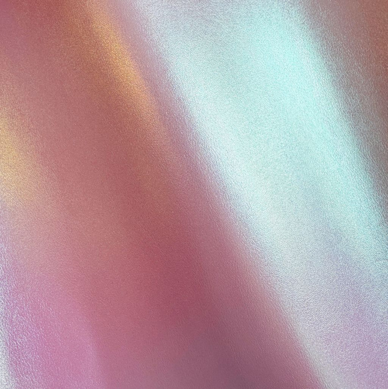 Close-up texture of Iridescent Lavender Vinyl fabric showing a color-shifting metallic sheen with pink, gold, and blue highlights.