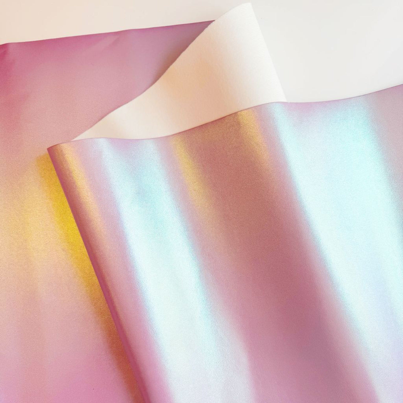 Draped sheet of Iridescent Lavender Vinyl color-shifting fabric vinyl showing a white backing and metallic pastel gradients.