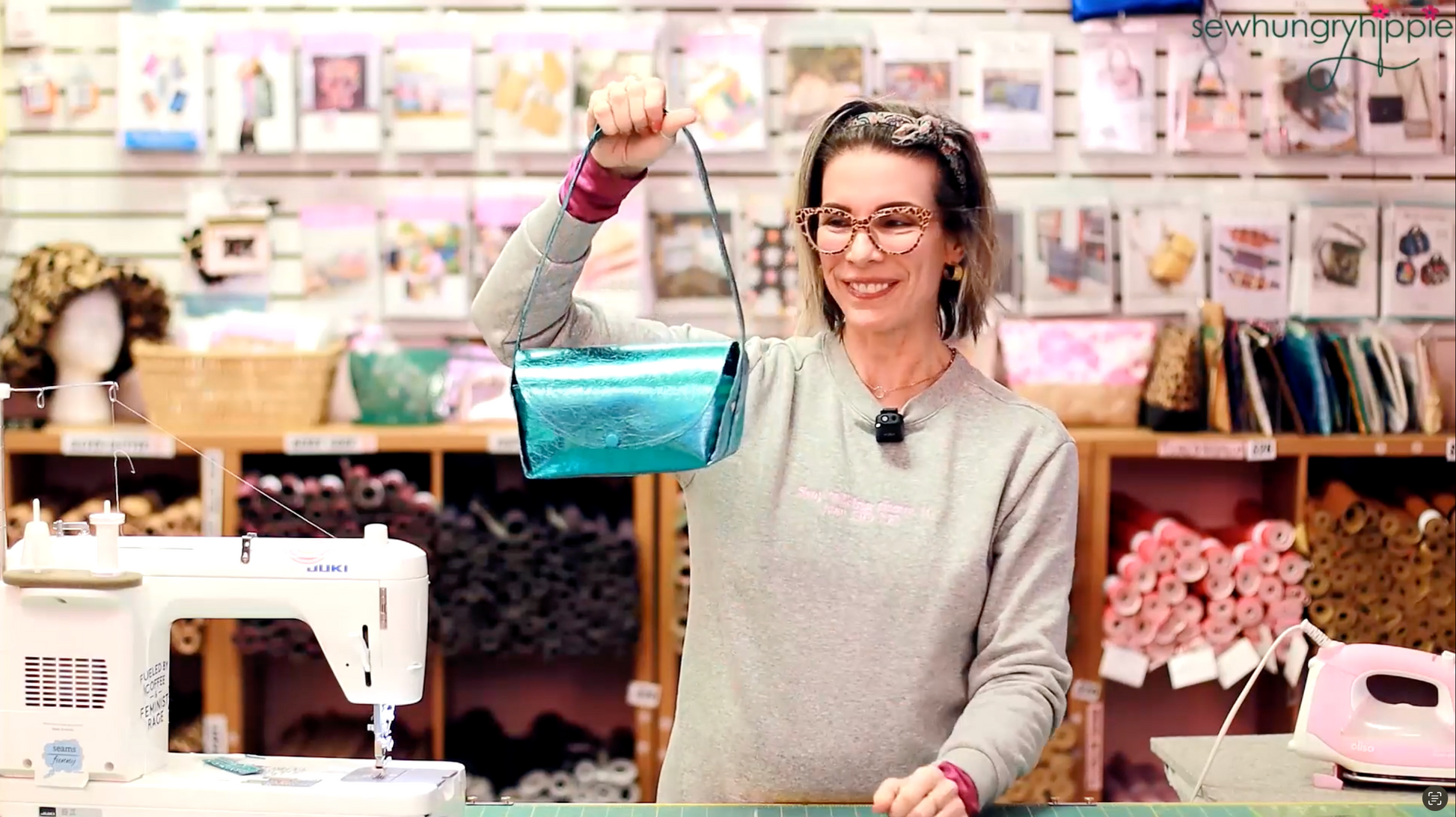 Natalie holding a handmade blue Jackie Bag in the Sew Hungry Hippie sewing studio