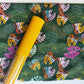This is the Art Gallery Fabrics "Jungle Tour" print from the Maara collection designed by Alexandra Bordallo, featuring a vibrant, multi-colored leaf pattern on a dark green cotton background