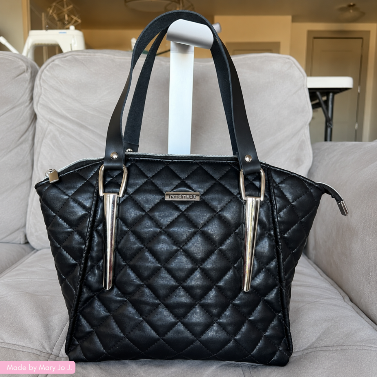 Quilted vinyl in black with one inch leather bag strap in black