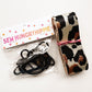 A roll of leopard-print woven nylon webbing and black hardware accessories from SewHungryhippie.