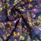 Close-up of Robert Kaufman Dreadful Delights fabric in midnight purple, showing a detailed spooky gothic design with realistic skulls, ravens, owls, spiderwebs, and dark floral arrangements.
