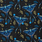 Seamless repeating pattern featuring large, stylized blue luna moths on a dark charcoal-black background. The moths have intricate wing details showing moon phases and botanical leaves. The background is filled with scattered celestial elements like yellow crescent moons, tiny stars, faint sunbursts, glowing blue orbs, and small leafy sprigs in blue and yellow.