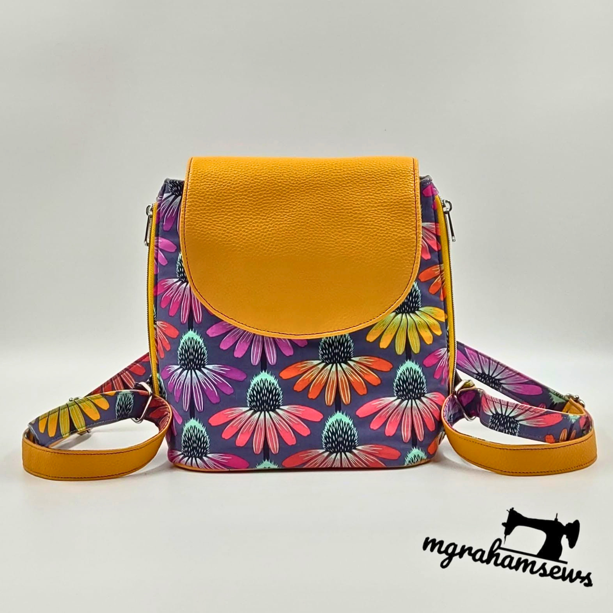 Small backpack with mustard Moonglow vinyl flap and colorful coneflower print body