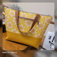 Tote in yellow and white floral print with mustard Moonglow vinyl base and brown handles, made by Linda M.