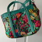 Colorful floral patchwork tote with Moonglow Teal vinyl accents and sturdy carrying straps.