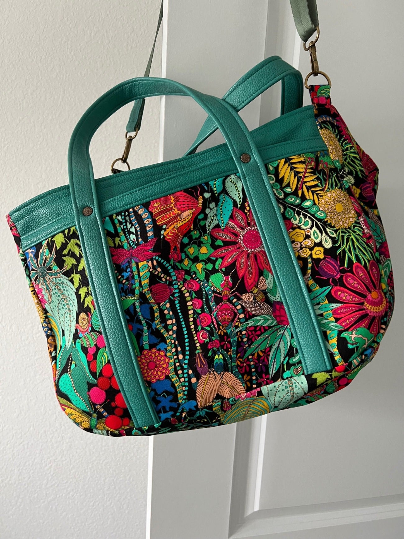 Colorful floral patchwork tote with Moonglow Teal vinyl accents and sturdy carrying straps.